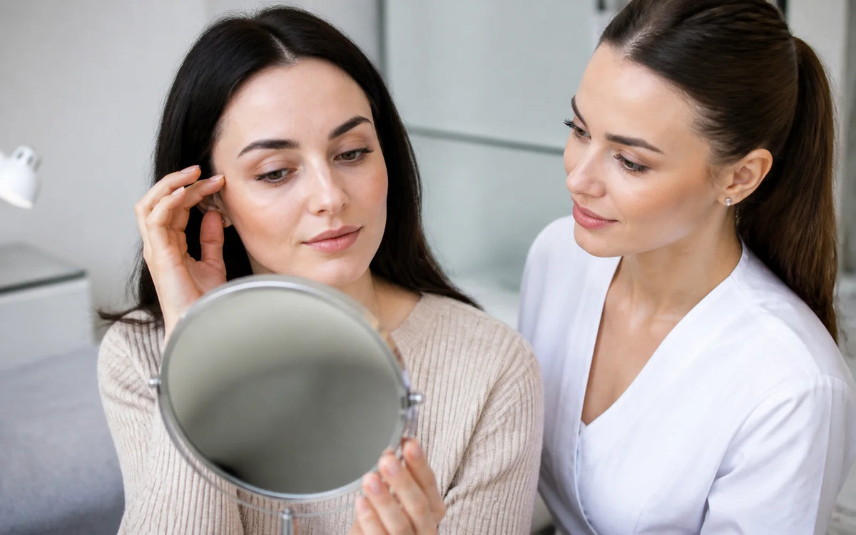 Adult client and lash professional examining natural lashes in a mirror