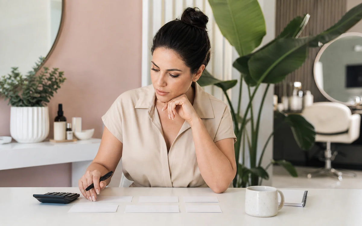 Adult beauty studio owner reviewing service pricing and capacity
